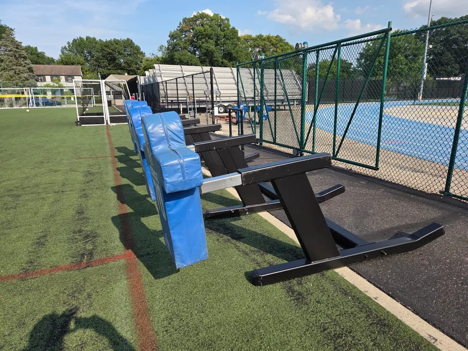 The same sleds after the work: refinished black frames with new blue pads, back out on the turf