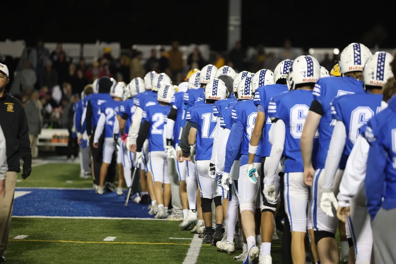 Bexley players lined up along the sideline under the lights