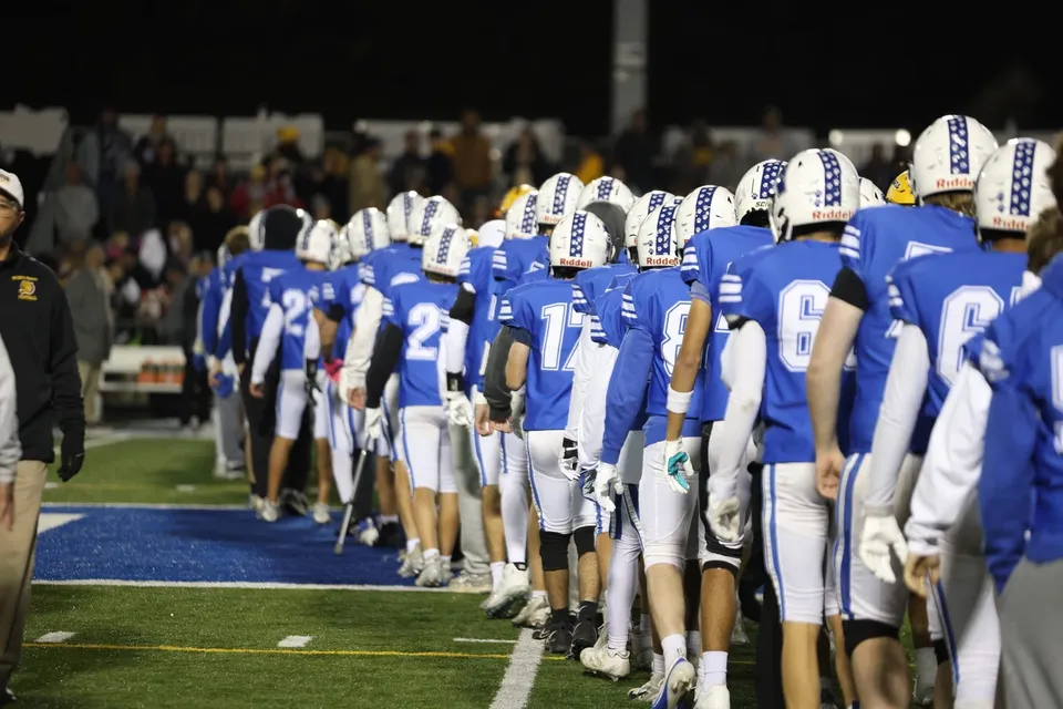 Bexley players lined up along the sideline under the lights